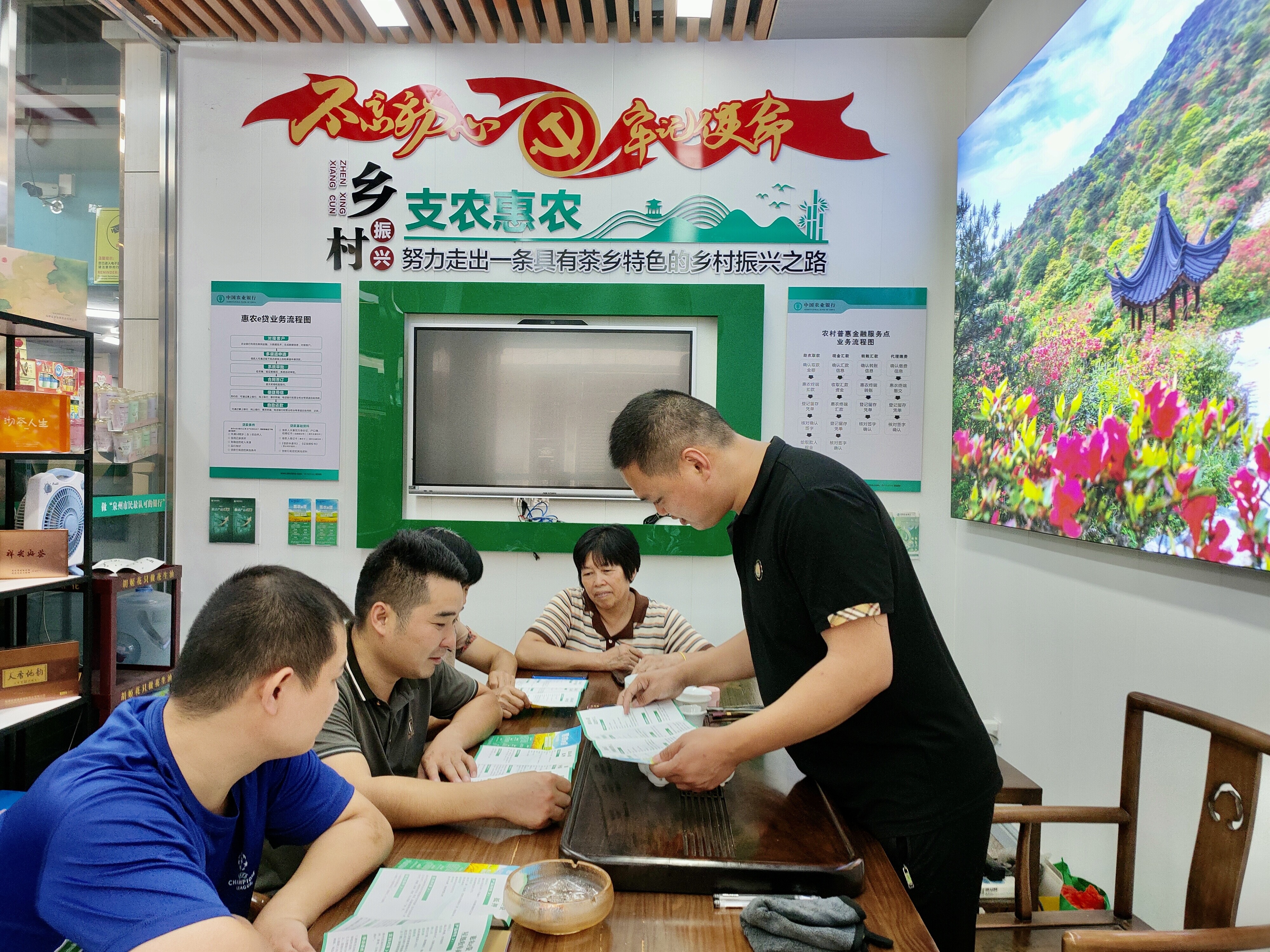 泉州安溪县祥华乡惠农服务旗舰店店主吴毅炎（右）正在给村民分享农行“富民贷”相关信息。
