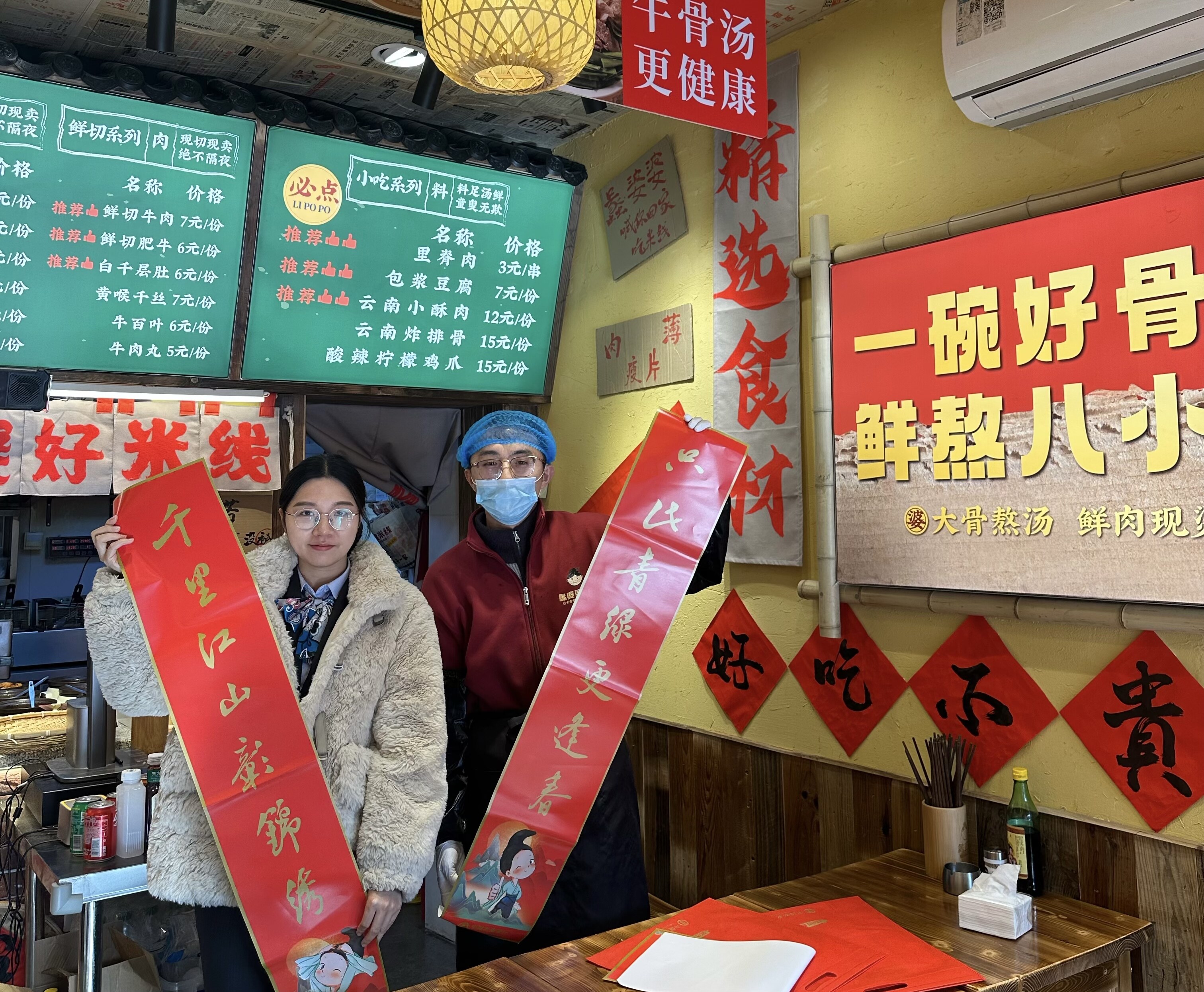 江苏苏州长三角一体化示范区分行员工在对接餐饮小店等经营主体金融需求的同时，还为他们送上了春联与福字。景行摄影报道