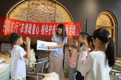 近日，农业银行江苏镇江丹阳支行举办“农情暖童心相伴护成长”主题活动。图为该行客户经理为小朋友讲解爱惜人民币的常识。