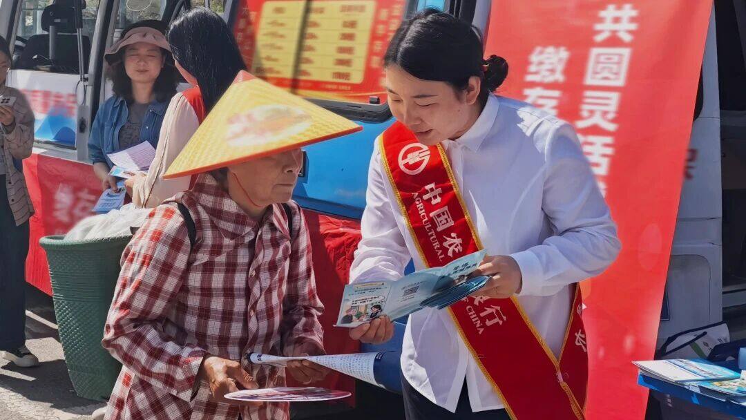 重庆酉阳支行员工走进龙潭镇，一方面宣讲防范电信网络诈骗知识，另一方面协助村民通过手机银行办理基础金融业务。 郭淳晰摄影报道