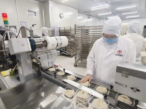华秀食品车间内，工人在制作锅盖面。